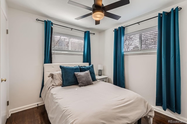 bedroom with multiple windows, wood finished floors, baseboards, and ceiling fan