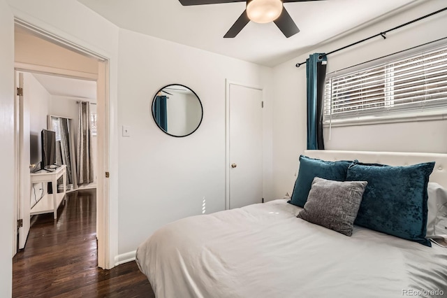 bedroom with multiple windows, baseboards, dark wood-style flooring, and ceiling fan