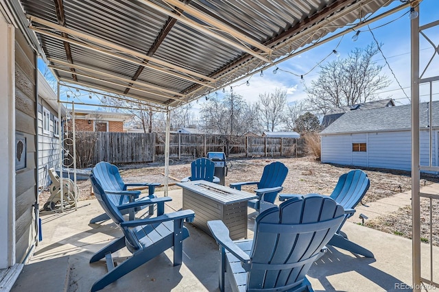 view of patio featuring an outbuilding, an outdoor fire pit, and a fenced backyard