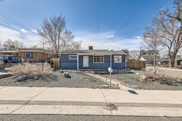 view of front of home with fence and a chimney