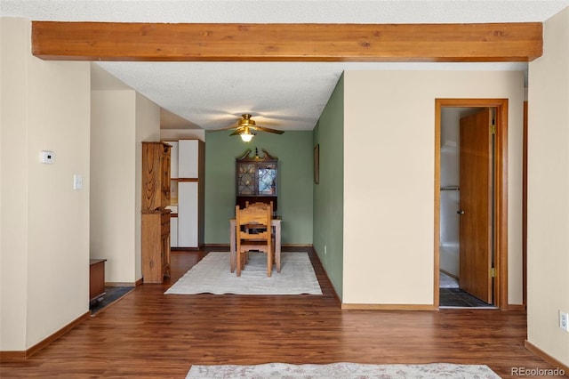 unfurnished dining area featuring a textured ceiling, ceiling fan, hardwood / wood-style floors, and beam ceiling