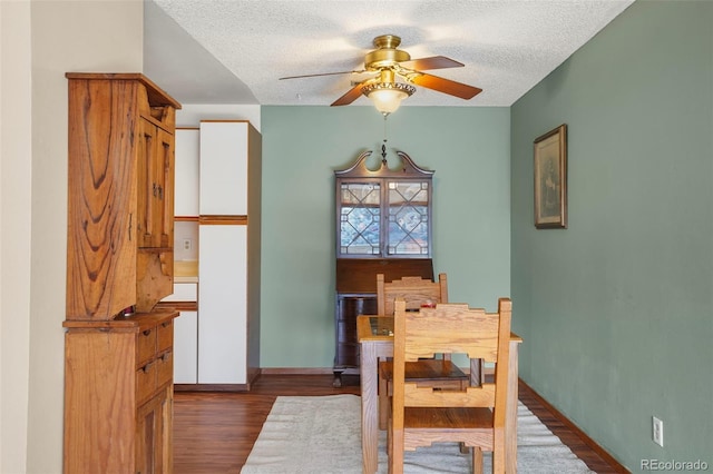 dining space featuring a textured ceiling, dark hardwood / wood-style flooring, and ceiling fan