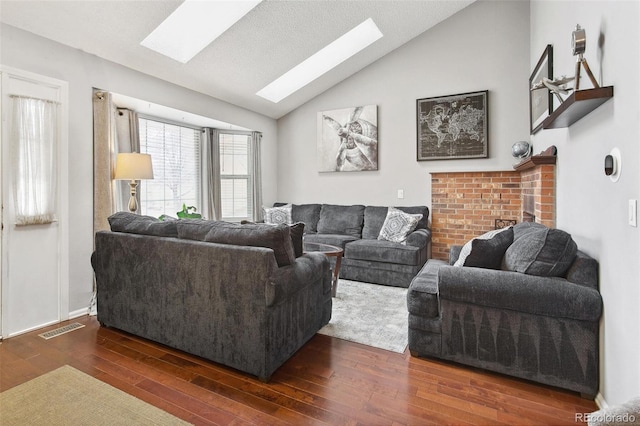 living room with vaulted ceiling with skylight and dark hardwood / wood-style floors