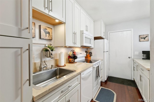 kitchen with white appliances, white cabinetry, sink, and dark hardwood / wood-style flooring