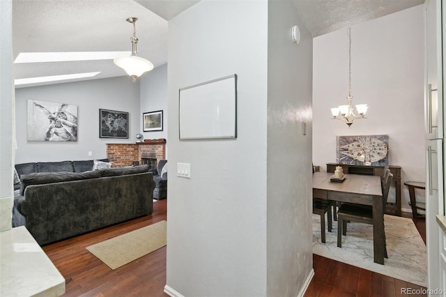 hallway featuring a notable chandelier, lofted ceiling, and dark hardwood / wood-style floors