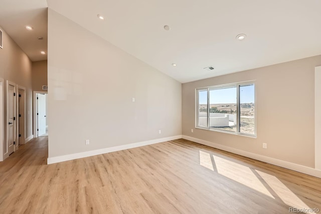 unfurnished room featuring light hardwood / wood-style flooring and high vaulted ceiling