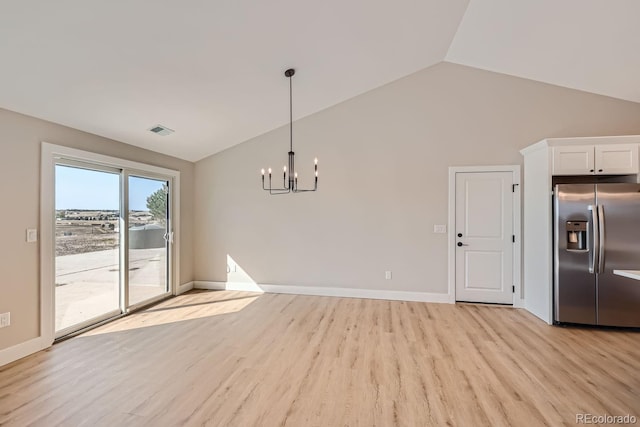 unfurnished dining area featuring light wood-type flooring, a chandelier, and vaulted ceiling