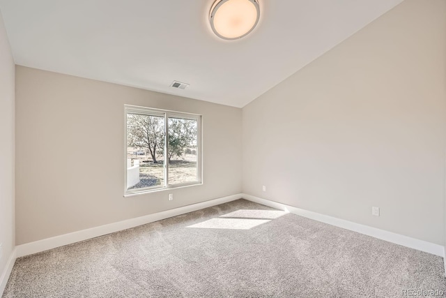 carpeted spare room with lofted ceiling