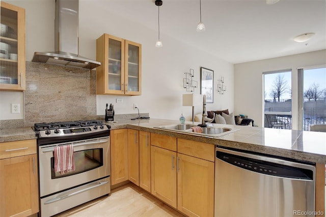 1438 Little Raven St Unit 306, Denver, CO 80202 - kitchen with appliances with stainless steel finishes, island range hood, a sink, a peninsula, and decorative backsplash