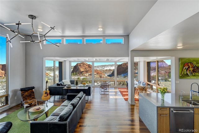 living room with dark hardwood / wood-style floors, a chandelier, sink, and a mountain view