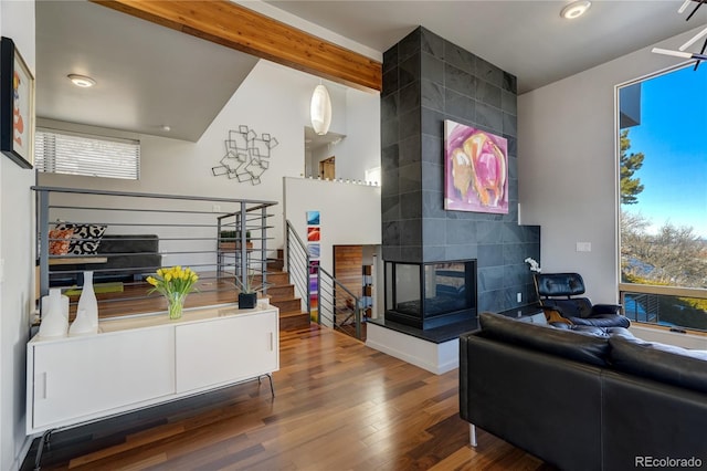 living room featuring beamed ceiling, hardwood / wood-style flooring, and a fireplace