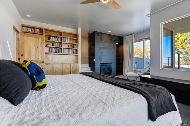 bedroom with a tiled fireplace, carpet floors, radiator, and ceiling fan