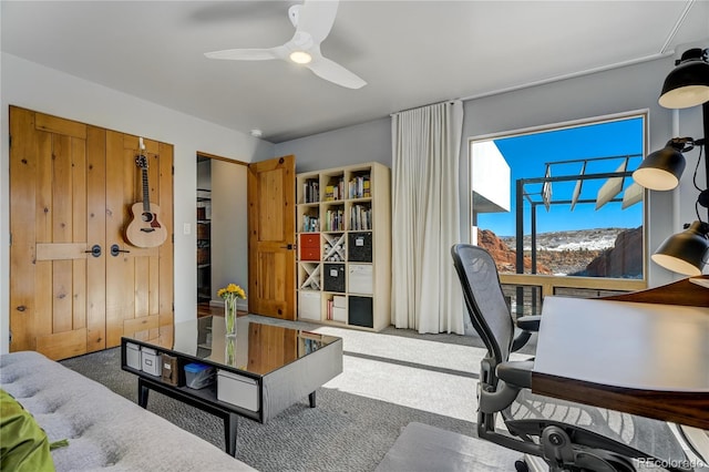 home office featuring a mountain view, ceiling fan, and carpet