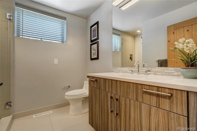 bathroom featuring tasteful backsplash, vanity, tile patterned floors, and toilet