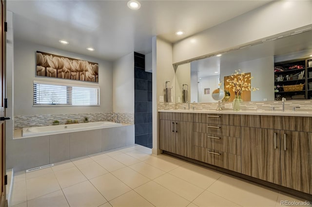 bathroom featuring vanity, tiled bath, and tile patterned flooring