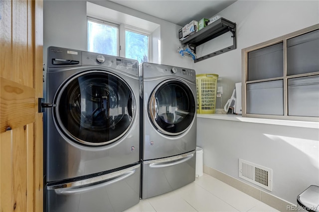 laundry area featuring light tile patterned floors and independent washer and dryer