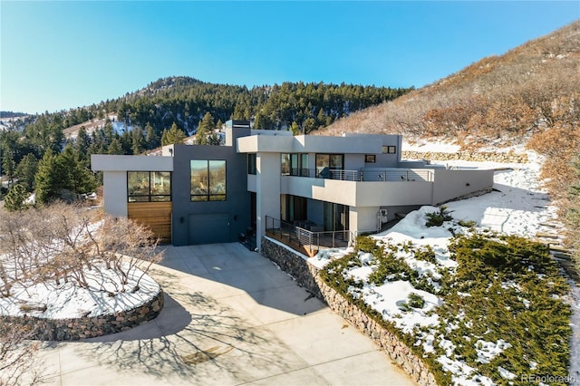 contemporary home featuring a balcony, a garage, and a mountain view