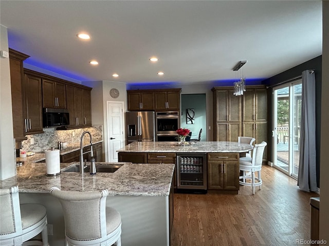 kitchen with stainless steel appliances, sink, pendant lighting, dark hardwood / wood-style floors, and wine cooler