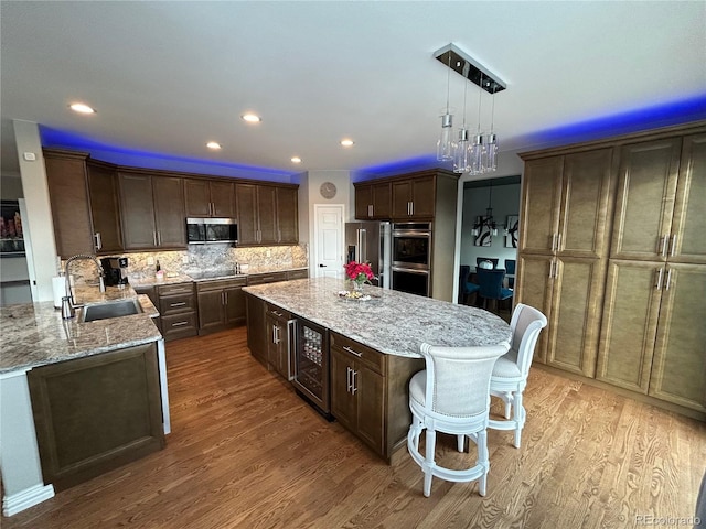 kitchen featuring sink, a center island, stainless steel appliances, wine cooler, and hardwood / wood-style floors