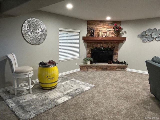 living room featuring a stone fireplace and carpet floors