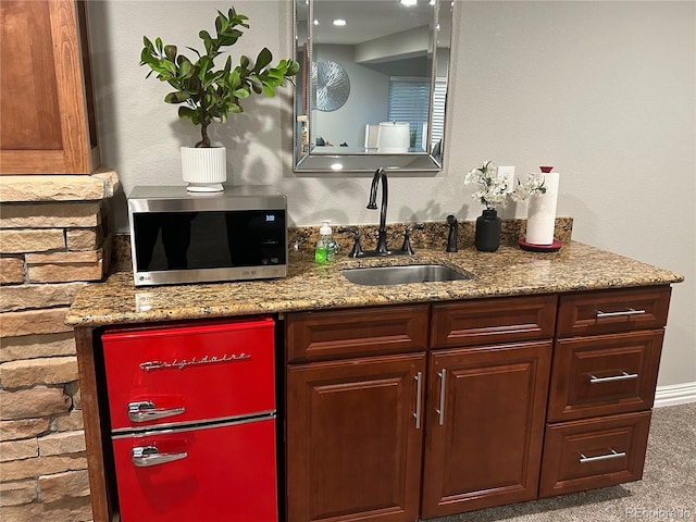 interior space with light colored carpet, light stone counters, and sink