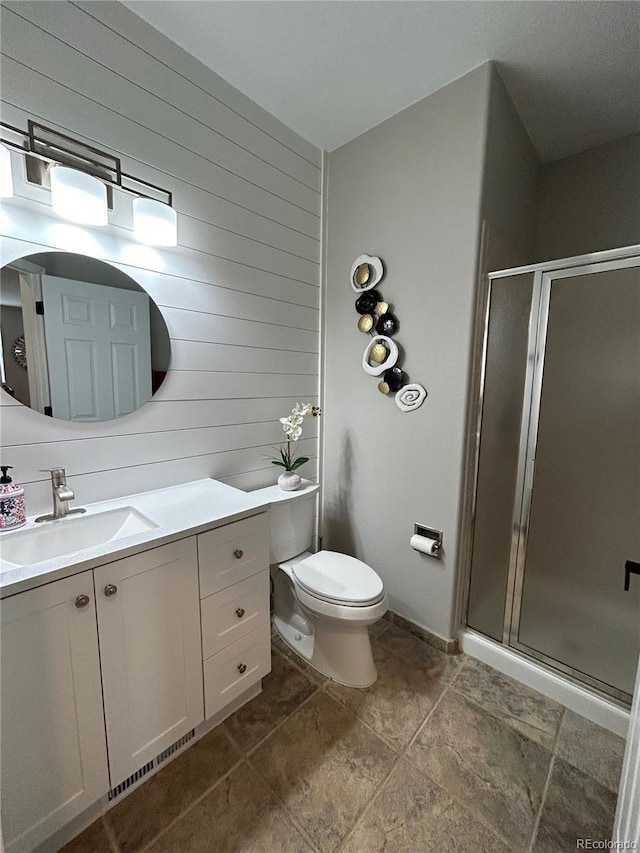 bathroom with vanity, toilet, and a shower with door