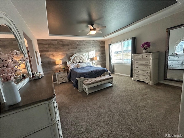 bedroom with carpet flooring, a raised ceiling, and ceiling fan