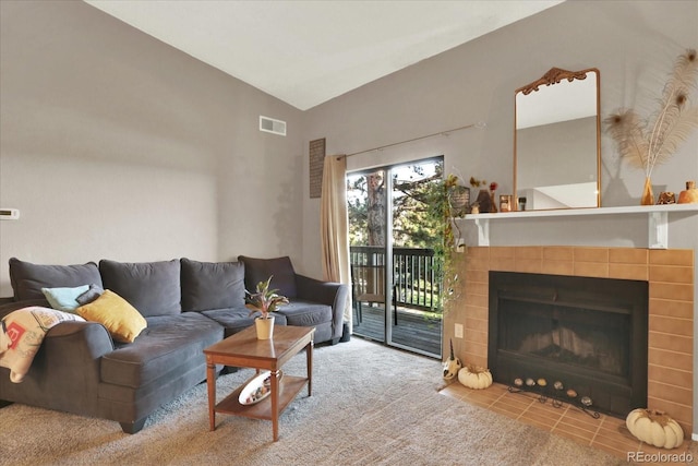 living room with a tiled fireplace and high vaulted ceiling