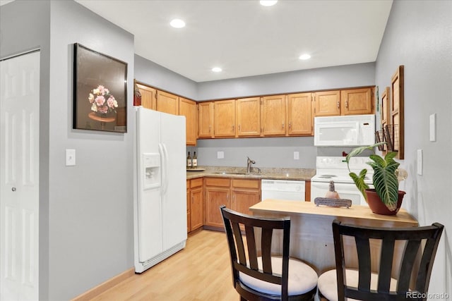 kitchen with light wood-type flooring, white appliances, and sink