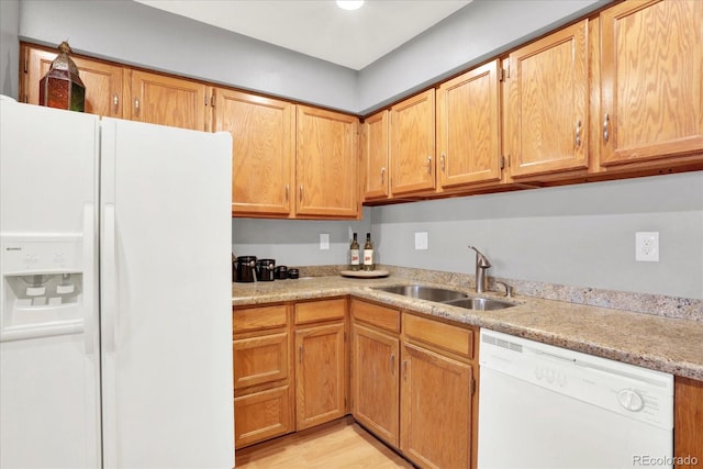 kitchen featuring light wood-type flooring, sink, and white appliances