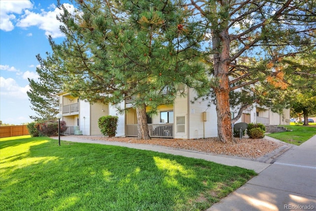 view of property hidden behind natural elements with a front lawn