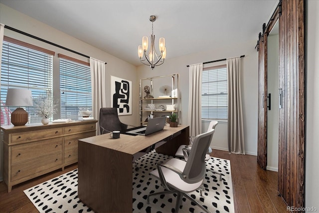 office area with a barn door, plenty of natural light, dark hardwood / wood-style floors, and a notable chandelier