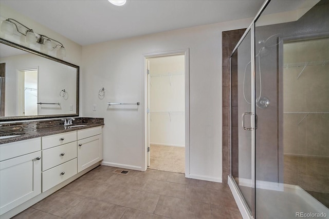 bathroom featuring vanity, tile patterned flooring, and walk in shower