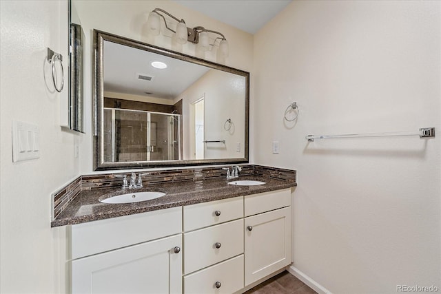 bathroom featuring vanity and a shower with shower door