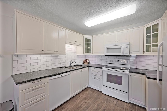 kitchen featuring a sink, glass insert cabinets, white cabinetry, and white appliances