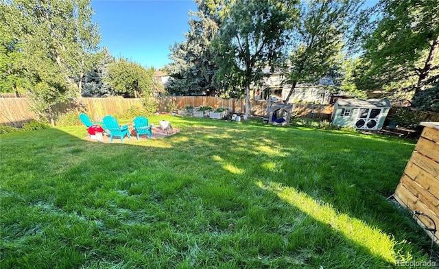 view of yard with a fenced backyard, a storage unit, and an outdoor structure