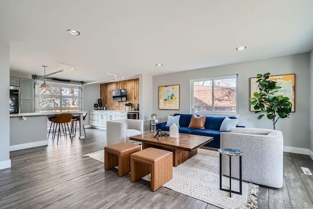 living room with recessed lighting, baseboards, and wood finished floors