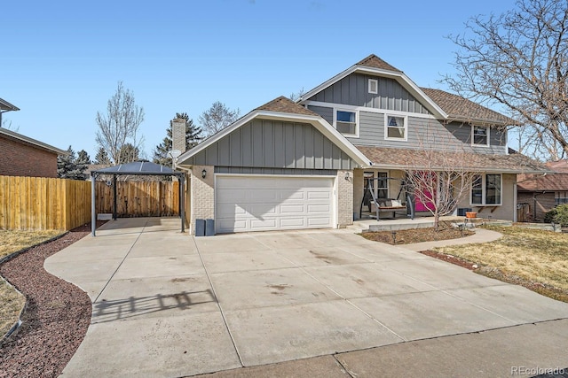 view of front of house featuring a gazebo, brick siding, board and batten siding, and driveway