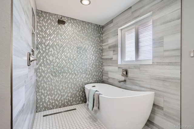 full bathroom with a freestanding bath, tile patterned flooring, tile walls, and a tile shower