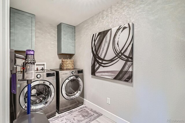 clothes washing area featuring laundry area, baseboards, and washer and clothes dryer