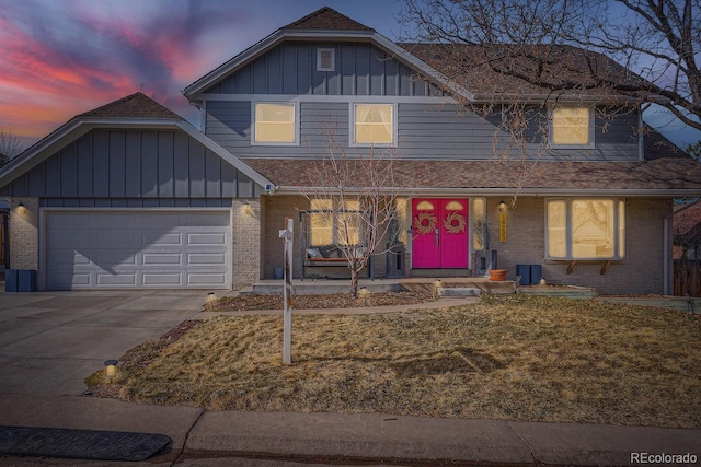 view of front facade featuring a garage, driveway, brick siding, and board and batten siding