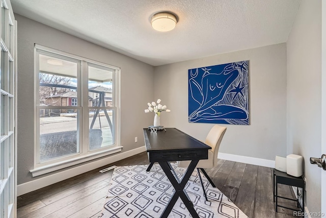 office area with visible vents, a textured ceiling, baseboards, and hardwood / wood-style floors