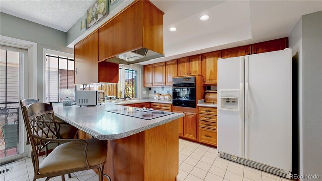 663 S Xenon Ct, Lakewood, CO 80228 - kitchen with white refrigerator with ice dispenser, oven, electric stovetop, a peninsula, and light countertops