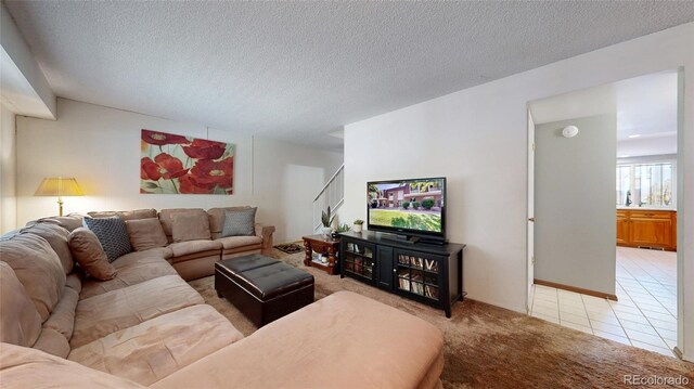 663 S Xenon Ct, Lakewood, CO 80228 - living room featuring light carpet, a textured ceiling, and light tile patterned floors