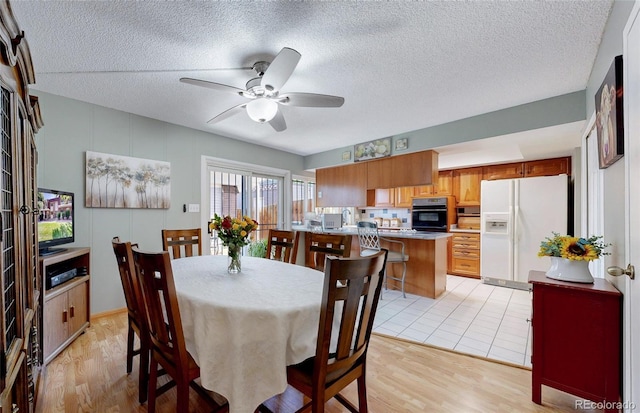 663 S Xenon Ct, Lakewood, CO 80228 - dining space featuring ceiling fan, light wood-type flooring, and a textured ceiling