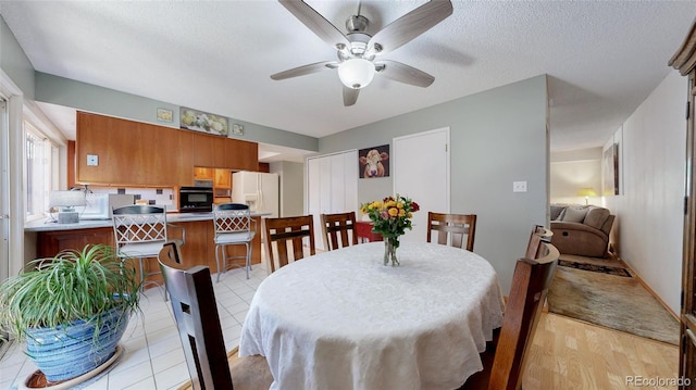 663 S Xenon Ct, Lakewood, CO 80228 - dining room with a ceiling fan, light wood-style flooring, and a textured ceiling