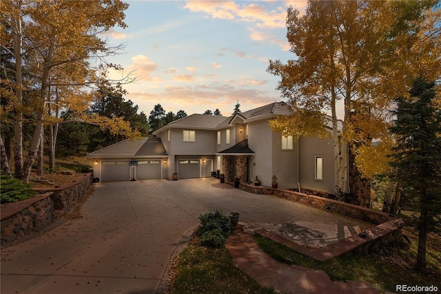 view of front of house with driveway, a garage, and stucco siding