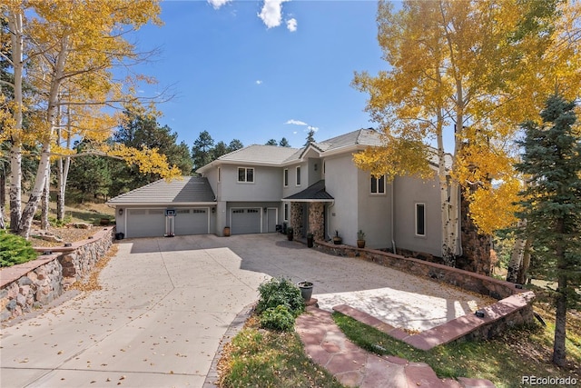 view of front of property featuring a garage, concrete driveway, and stucco siding