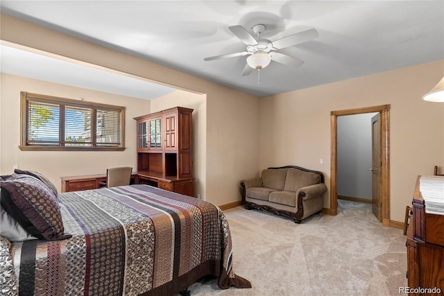 bedroom featuring light carpet, a ceiling fan, and baseboards