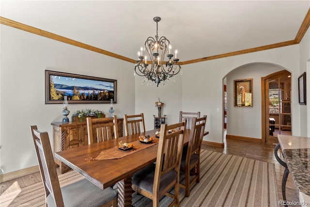 dining space with baseboards, arched walkways, an inviting chandelier, crown molding, and light wood-type flooring